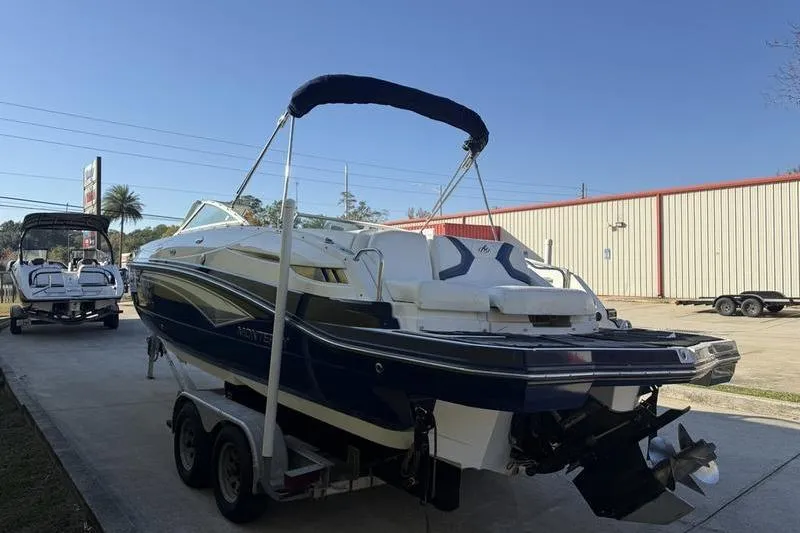 Slide: The Image of 2010 Monterey M5 Sport Boat on trailer, parked outdoors under clear sky. - 10