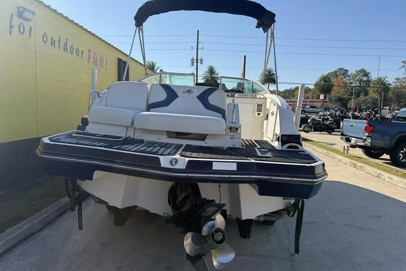 Slide: The Image of 2010 Monterey M5 Sport Boat, rear view, parked outdoors, showcasing propeller and seating area. - 11