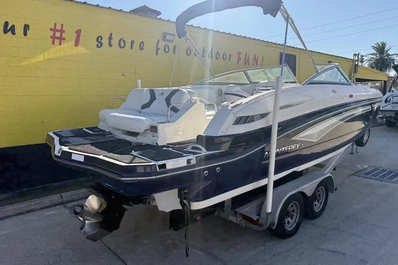 Slide: The Image of 2010 Monterey M5 Sport Boat on trailer, parked outside a yellow building. - 12