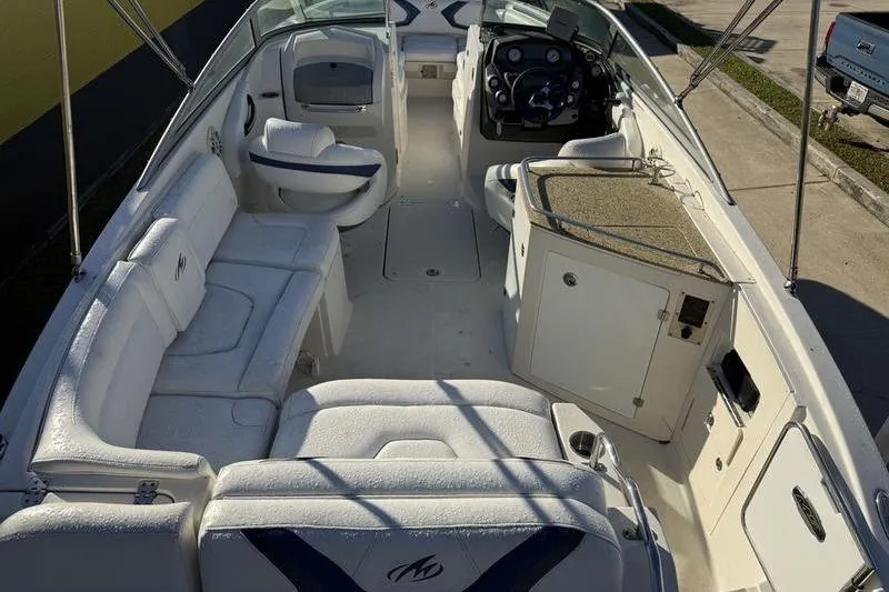 Slide: The Image of 2010 Monterey M5 Sport Boat interior with white seating and modern dashboard. - 13