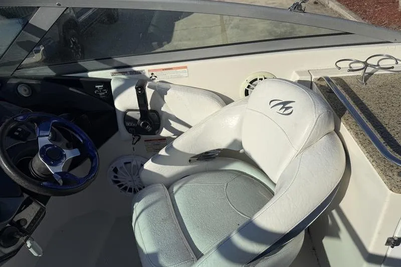 Slide: The Image of Interior of a 2010 Monterey M5 Sport Boat with white seating and steering wheel. - 17