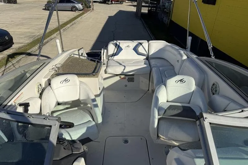 Slide: The Image of 2010 Monterey M5 Sport Boat interior with white seating and open deck layout. - 22