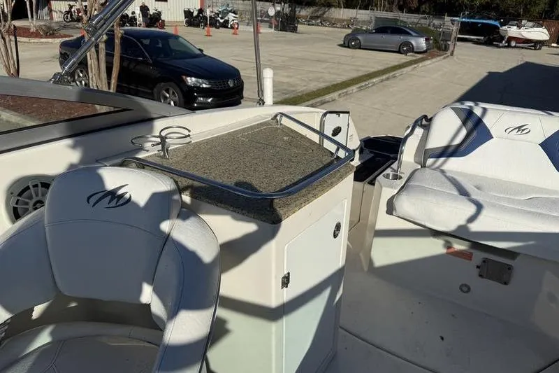 Slide: The Image of 2010 Monterey M5 Sport Boat interior with seating and countertop in a parking area. - 23