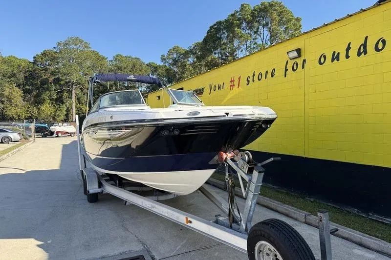 Slide: The Image of 2010 Monterey M5 Sport Boat on trailer, parked outside a yellow building. - 3