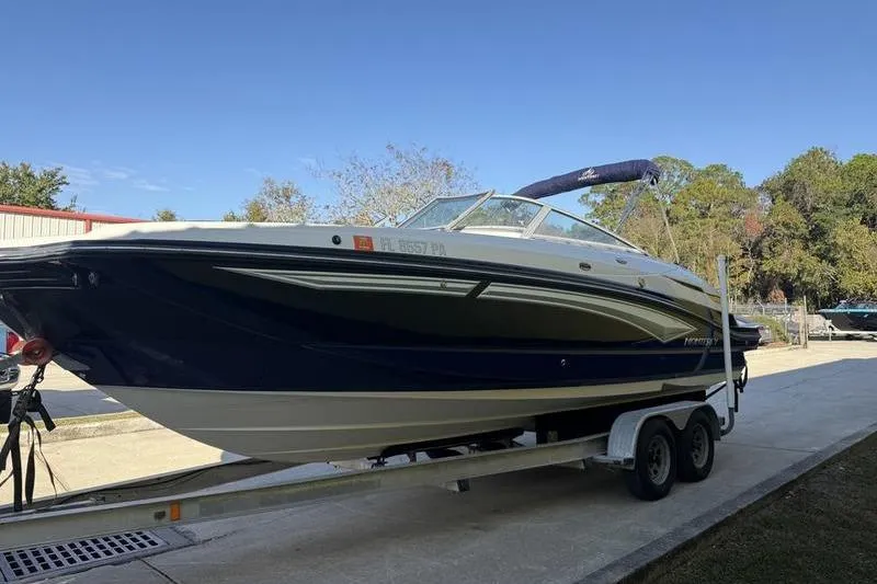Slide: The Image of 2010 Monterey M5 Sport Boat on trailer, parked outdoors under clear blue sky. - 6