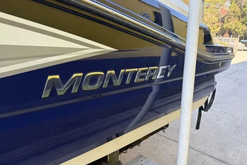 Slide: The Image of 2010 Monterey M5 Sport Boat, blue exterior with logo, parked outdoors. - 9