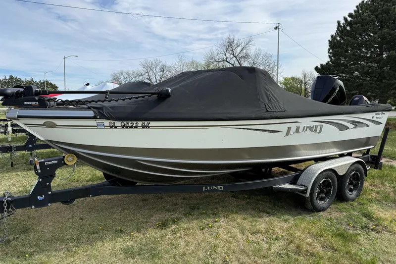 Slide: The Image of 2019 Lund 1950 Tyee Magnum ITS boat on trailer, covered, parked on grass. - 2