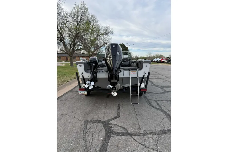 Slide: The Image of 2019 Lund 1950 Tyee Magnum ITS boat with dual motors and ladder, parked on street. - 7