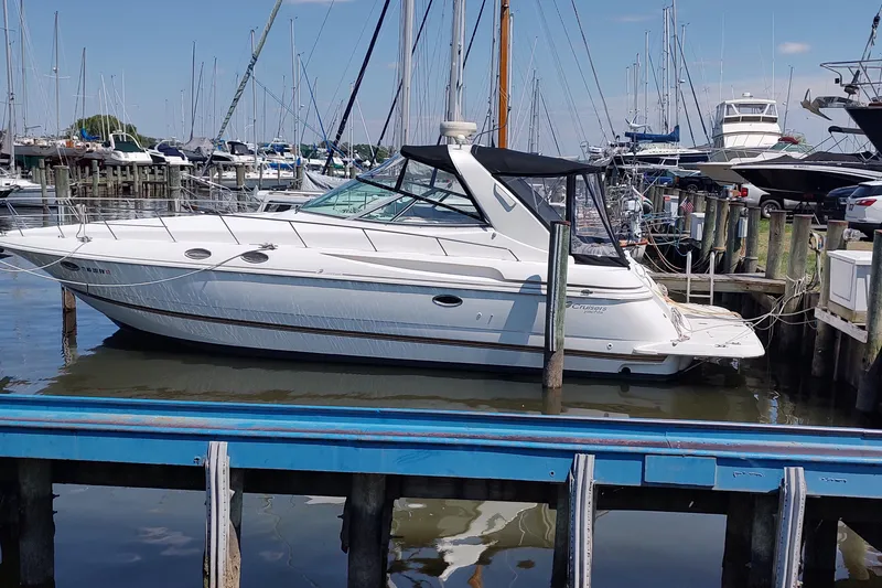 The Image of 1998 Cruisers Yachts 3870 Express docked at a marina with other boats. - 0