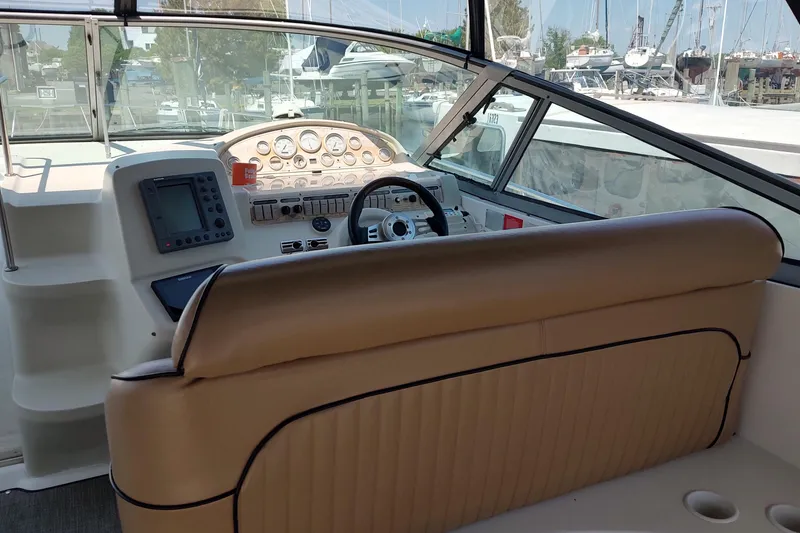 Slide: The Image of 1998 Cruisers Yachts 3870 Express helm with beige seating and navigation instruments. - 17