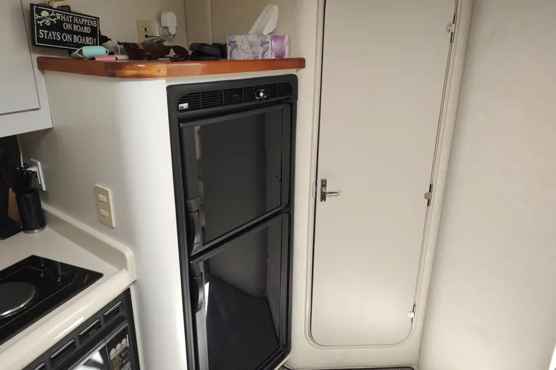 Slide: The Image of 1998 Cruisers Yachts 3870 Express interior with fridge and cabin door. - 25