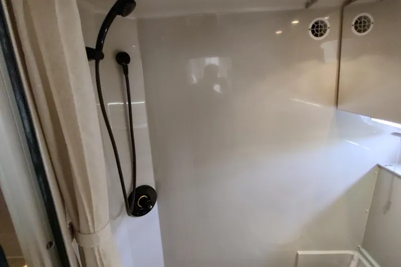 Slide: The Image of Shower area inside 1998 Cruisers Yachts 3870 Express, featuring modern fixtures and ventilation. - 30