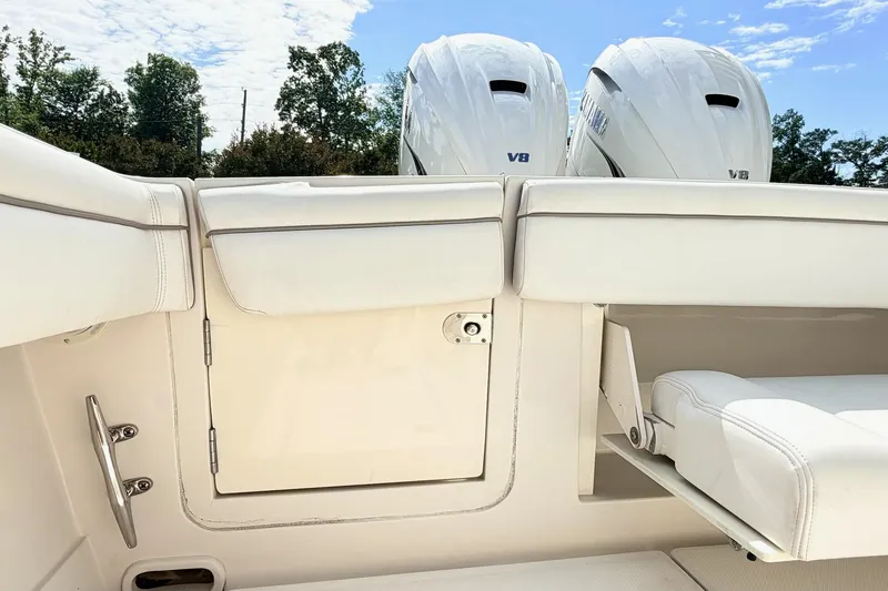 Slide: The Image of 2012 Jupiter 34 FS boat interior with dual V8 engines, white seating, and storage compartment. - 11