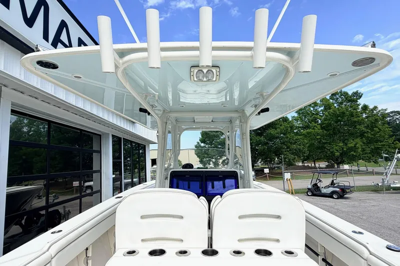 Slide: The Image of 2012 Jupiter 34 FS boat with T-top and rod holders, docked near a building. - 13