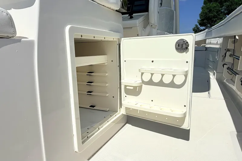Slide: The Image of Open storage compartment on 2012 Jupiter 34 FS boat, featuring shelves and holders. - 16