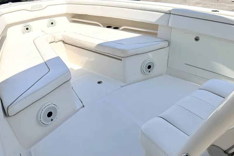 Slide: The Image of Spacious seating area on a 2012 Jupiter 34 FS boat, featuring white upholstery. - 17