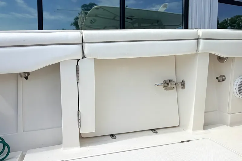 Slide: The Image of 2012 Jupiter 34 FS boat interior with white cushioned seating and storage compartment. - 5