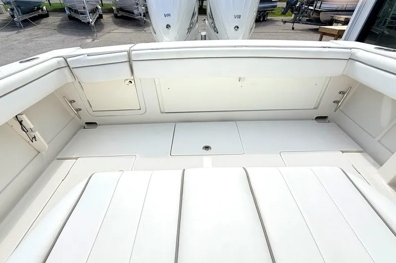 Slide: The Image of 2012 Jupiter 34 FS boat interior with white seating and storage compartments. - 9