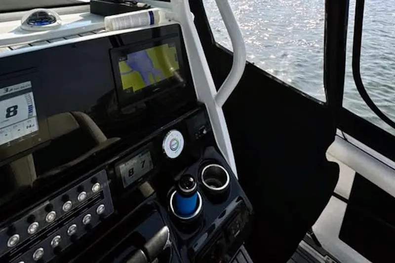 Slide: The Image of Interior view of 2021 Tidewater 256 CC Adventure boat dashboard with navigation screens. - 2