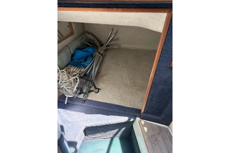 Slide: The Image of Interior storage of 1987 Four Winns 245 Vista boat with ropes and metal poles. - 5