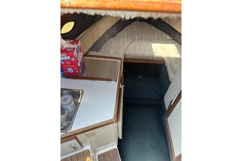 Slide: The Image of Interior of 1987 Four Winns 245 Vista boat with kitchenette and seating area. - 7