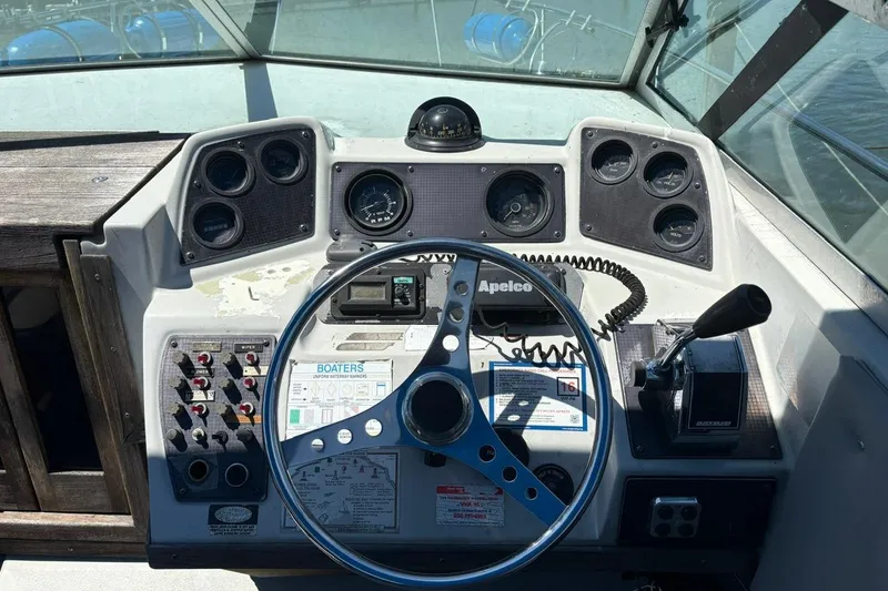 Slide: The Image of 1987 Four Winns 245 Vista boat dashboard with steering wheel and control panel. - 9