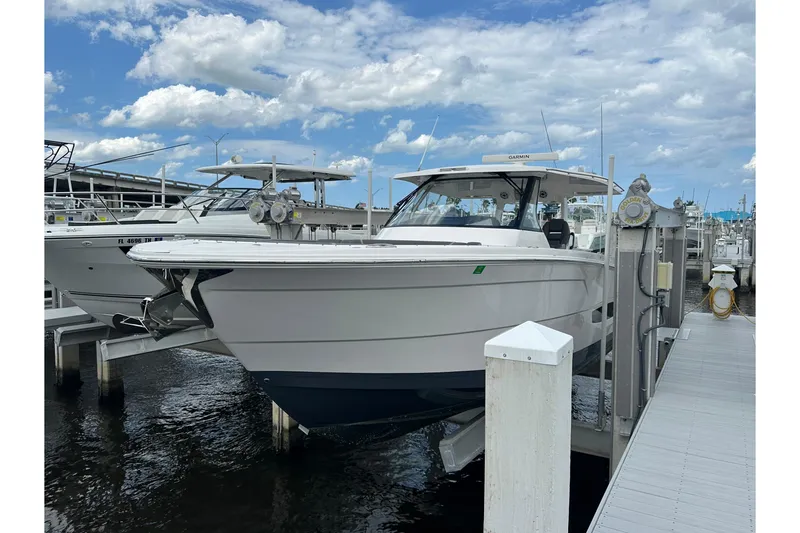 The Image of 2025 Regal 38 SAV boat docked at marina under blue sky. - 0