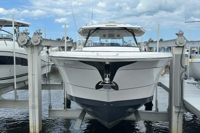 Slide: The Image of 2025 Regal 38 SAV boat docked at marina under cloudy sky. - 1