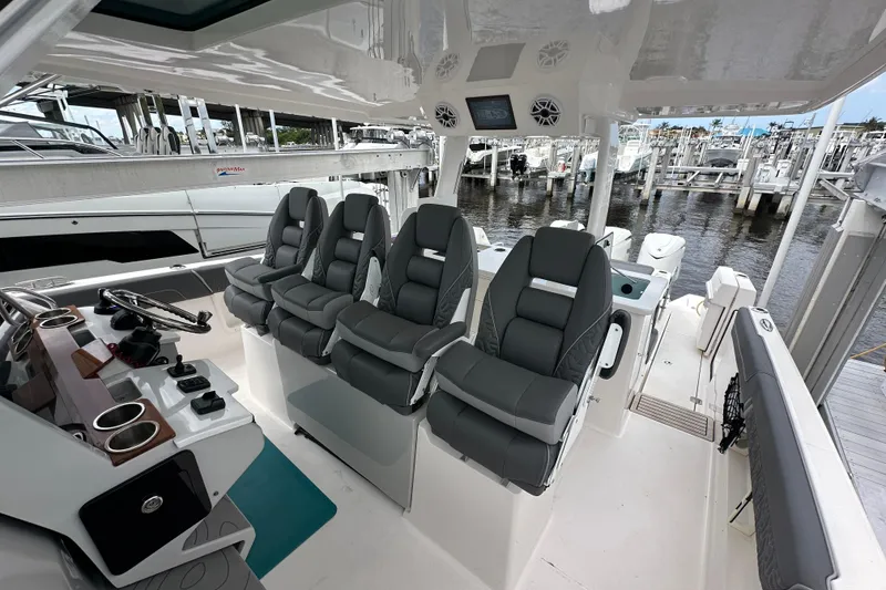 Slide: The Image of 2025 Regal 38 SAV boat interior with luxurious seating and modern helm at a marina. - 10
