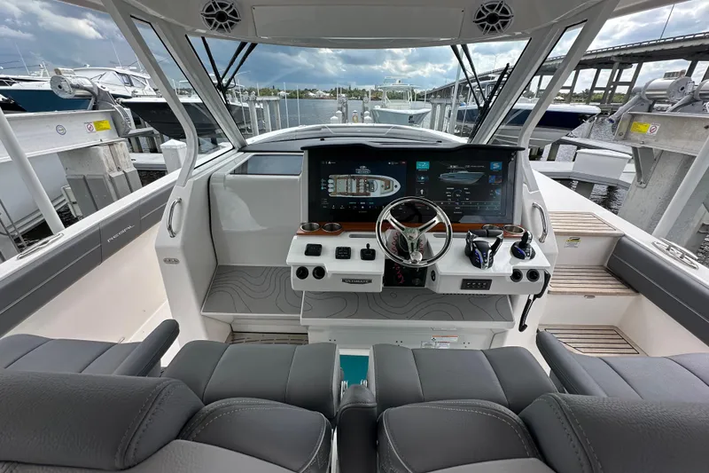 Slide: The Image of 2025 Regal 38 SAV boat helm with modern controls and dual screens at marina. - 11