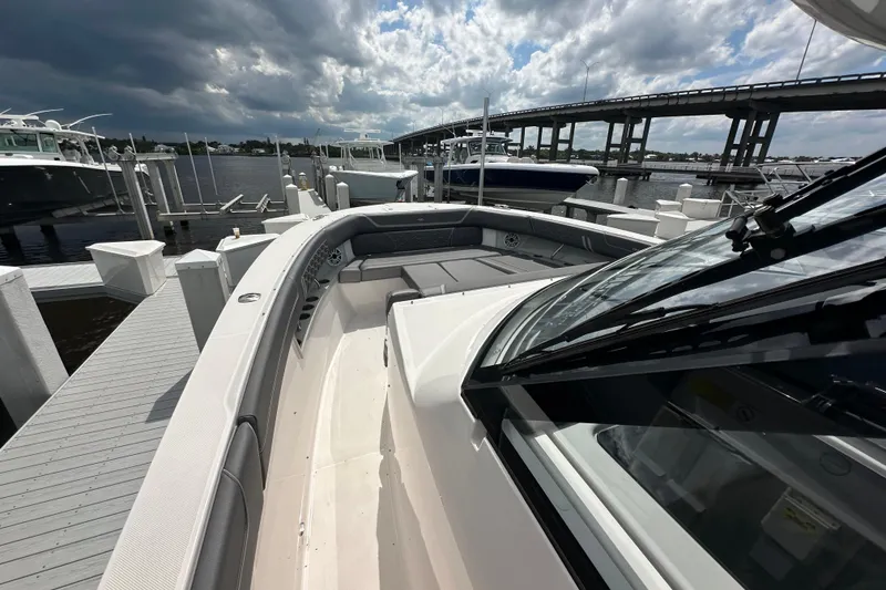 Slide: The Image of 2025 Regal 38 SAV boat docked under cloudy skies near a bridge. - 16