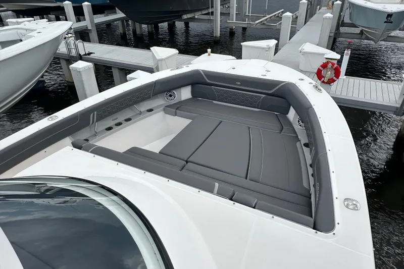 Slide: The Image of 2025 Regal 38 SAV boat with spacious gray seating at a marina dock. - 18
