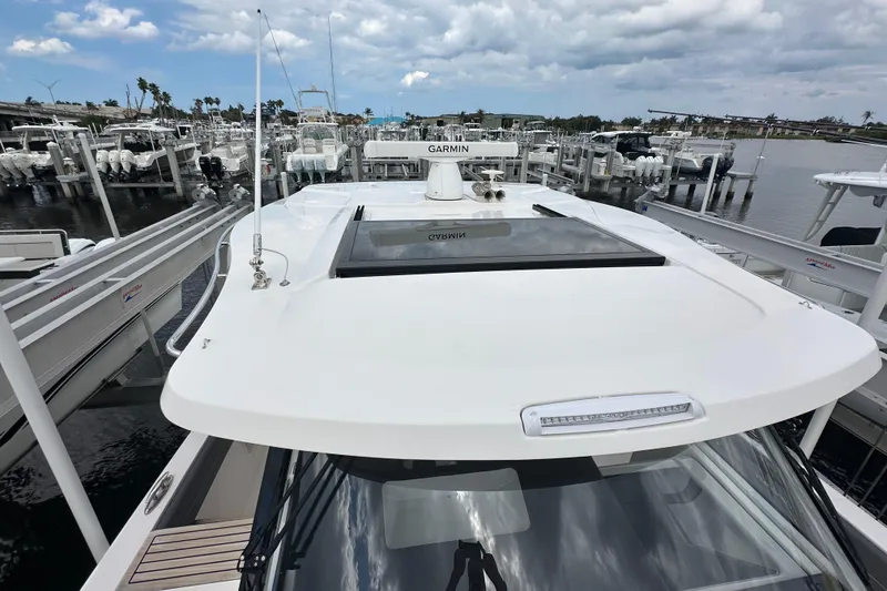 Slide: The Image of 2025 Regal 38 SAV boat docked at marina, featuring Garmin equipment and sleek design. - 19