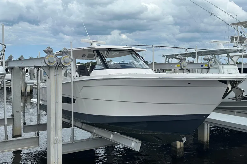 Slide: The Image of 2025 Regal 38 SAV boat docked at marina under cloudy sky. - 2