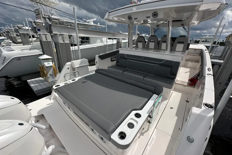 Slide: The Image of 2025 Regal 38 SAV luxury boat with spacious seating and sleek design at a marina. - 6
