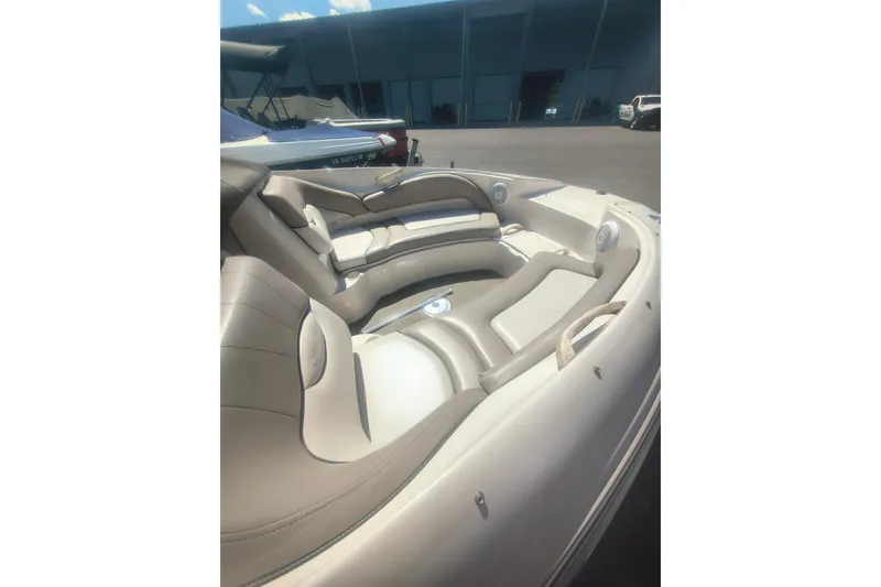 Slide: The Image of 2004 Sun Deck 220 boat interior with beige seating and speakers. - 3