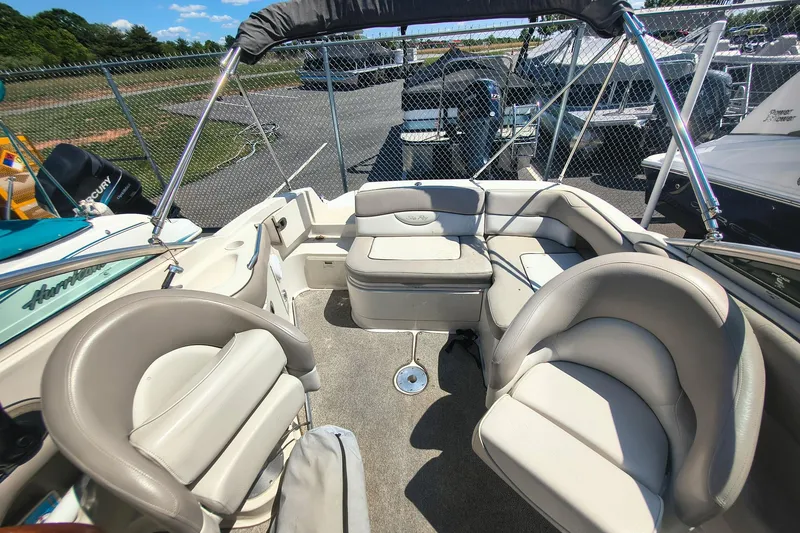 Slide: The Image of Interior of a 2004 Sun Deck 220 boat with beige seating and open canopy. - 5