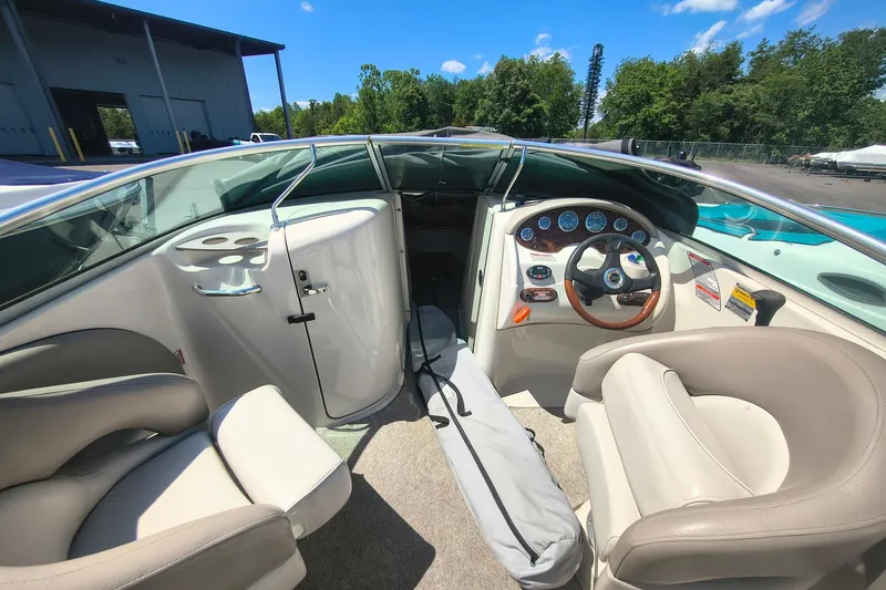 Slide: The Image of Interior of a 2004 Sun Deck 220 boat with steering wheel and seating. - 7
