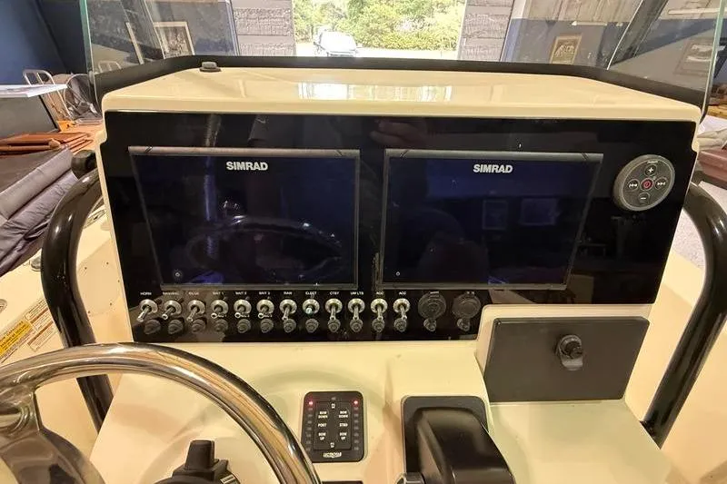 Slide: The Image of 2023 Sea Born FX22 Bay boat dashboard with dual Simrad displays and controls. - 11