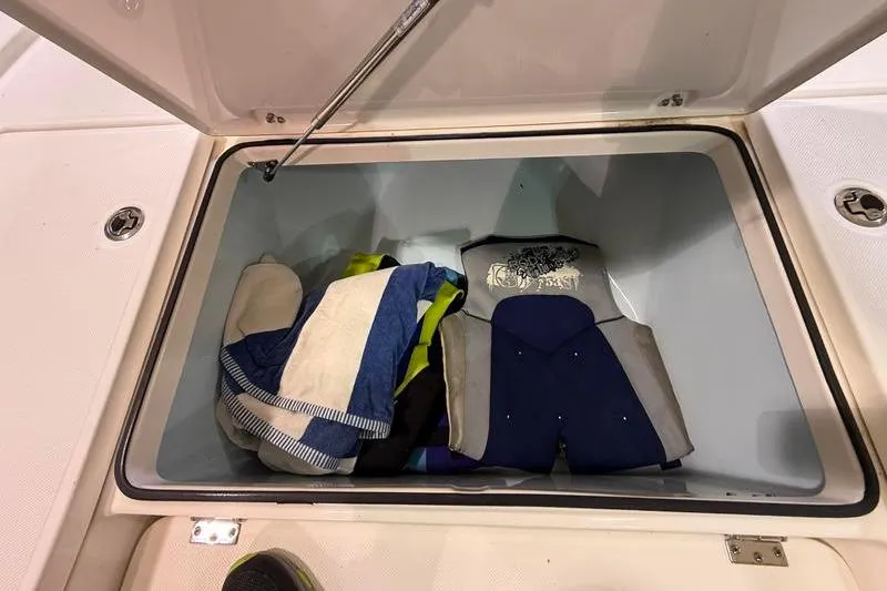 Slide: The Image of Open storage compartment on 2023 Sea Born FX22 Bay boat with towels and gear. - 19