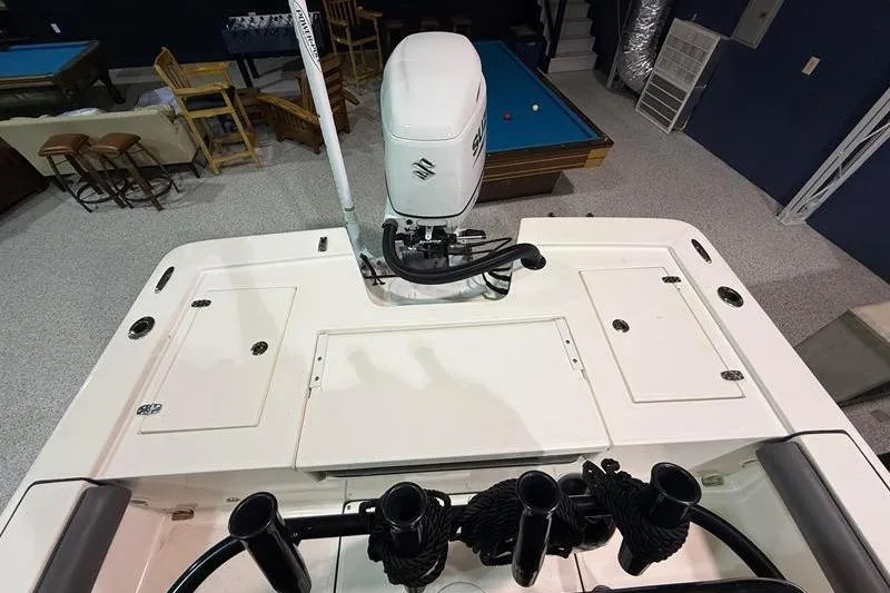 Slide: The Image of 2023 Sea Born FX22 Bay boat interior with motor, in a recreational room setting. - 7