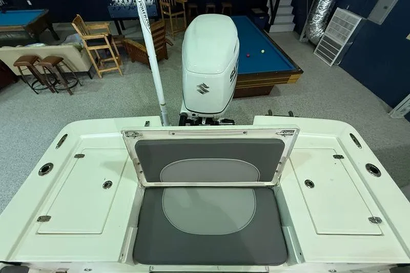 Slide: The Image of 2023 Sea Born FX22 Bay boat with Suzuki outboard motor in a recreational room setting. - 8