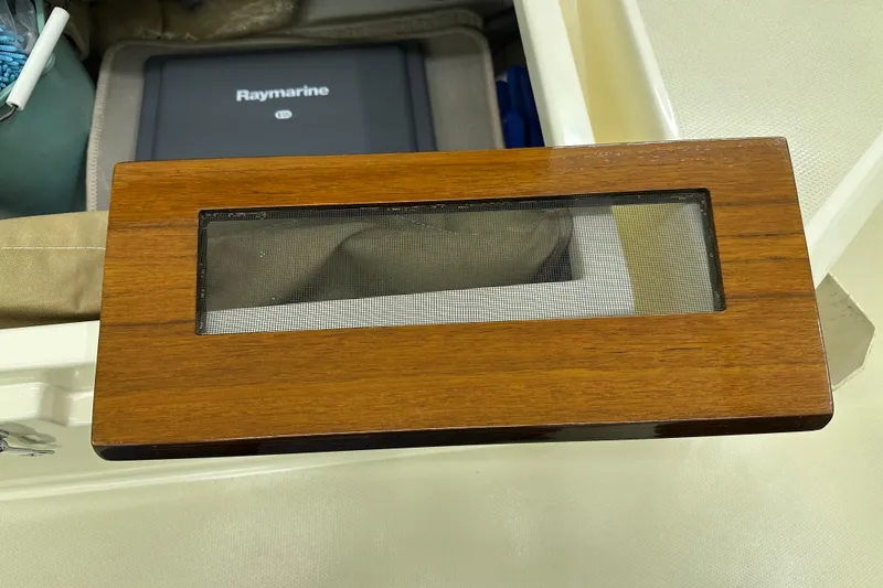 Slide: The Image of Wooden panel with mesh screen on Sabre 386, 2007 model, near Raymarine device. - 114