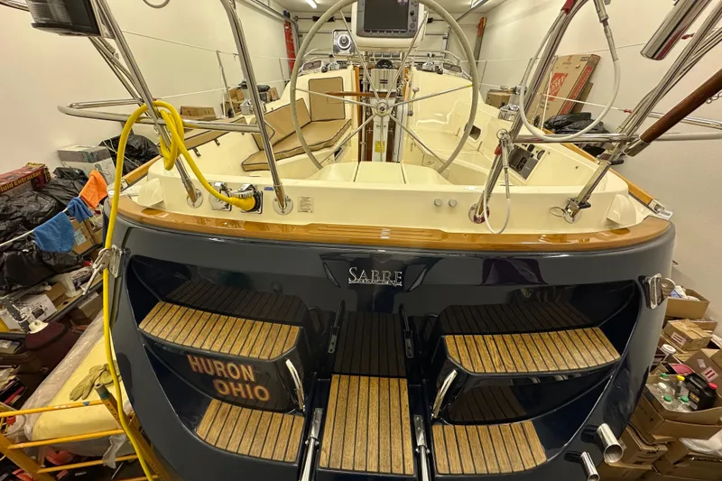 Slide: The Image of 2007 Sabre 386 sailboat in storage, featuring a polished deck and wooden steps. - 118