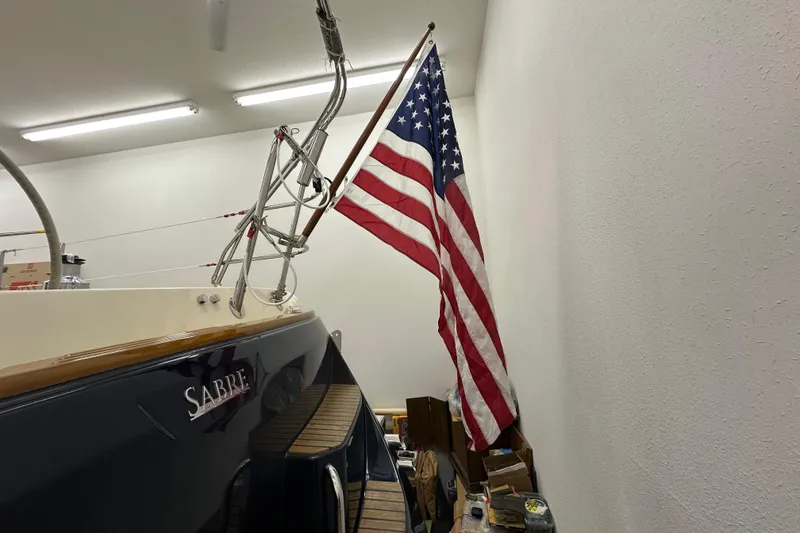 Slide: The Image of Sabre 386 sailboat from 2007 with American flag in a garage setting. - 120