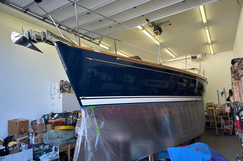 Slide: The Image of Sailboat Sabre 386 (2007) in a workshop, partially covered, with visible anchor and equipment. - 125