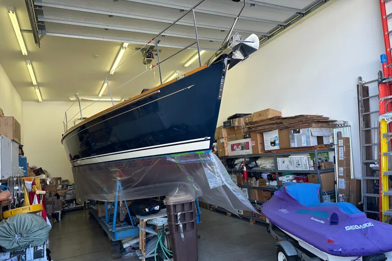 Slide: The Image of 2007 Sabre 386 sailboat stored indoors, surrounded by boxes and a Sea-Doo watercraft. - 126