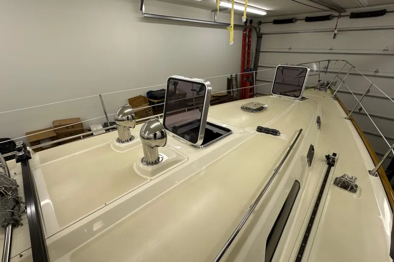 Slide: The Image of 2007 Sabre 386 yacht deck in a garage, featuring open hatches and chrome fittings. - 127