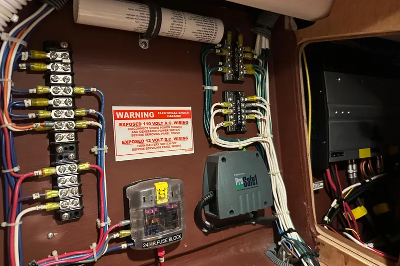 Slide: The Image of Electrical panel with wiring and warning label in a 2007 Sabre 386 boat. - 136