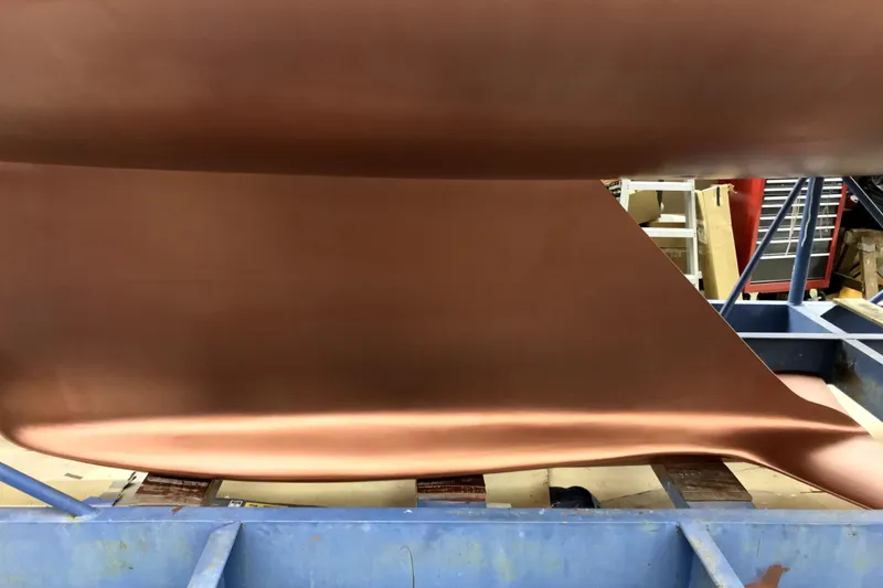 Slide: The Image of Copper-colored sailboat keel in a workshop, Sabre 386, 2007 model. - 155